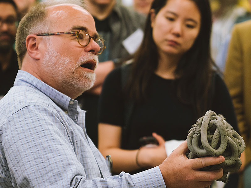 DBL director Russell Gentry shows a building material to the Lab's Symposium visitors.