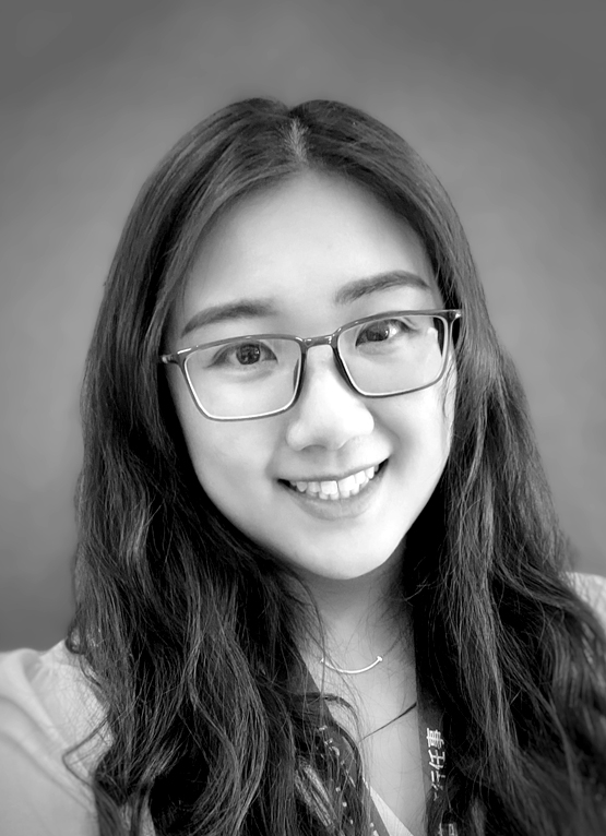 This is a grayscale portrait of Dr. Tang. She is smiling towards the camera against a background with architectural features.