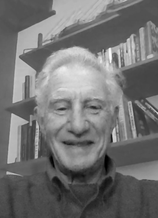 This is a grayscale portrait of Dr. Teicholz, he is smiling towards the camera, there are out of focus bookshelves in the background