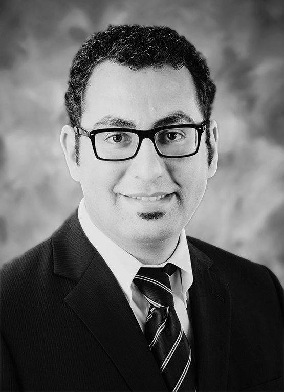 This is a grayscale portrait of Dr. Gheisari. He is looking towards the camera wearing a dark suit and a tie.